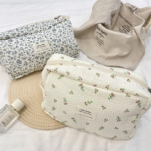 Close-up of quilted floral cosmetic bags with blue and red patterns and woven textures