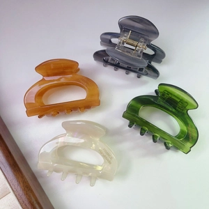 Set of four glossy acetate shark hair clips in amber, gray, green and cream white colors