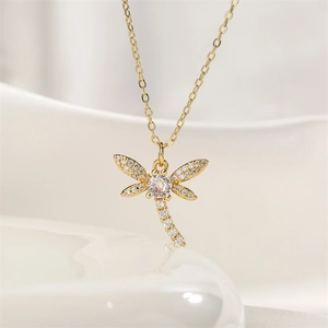Detailed close-up of a golden dragonfly pendant featuring sparkling white zircon stones