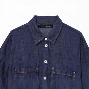 Camicia di jeans blu scuro con colletto botton-down e taschino su sfondo bianco