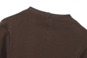 Detail of dark brown ribbed knit fabric showing high collar stitching and fine texture