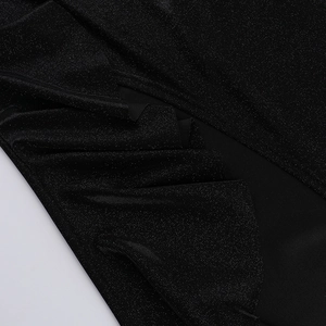 Close-up of black sequined fabric showing shiny metallic texture and fine stitching detail