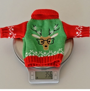 Detailed view of festive knitted Christmas wine bottle cover with reindeer embroidery