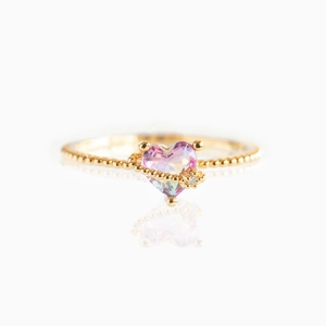 Elegant gold beaded ring with heart-shaped purple gradient gemstone and clear accent stone
