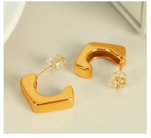 Detailed close-up of 18k gold-plated geometric C-shaped earrings with silicone backs