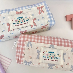 Close-up of pink and blue plaid canvas pencil cases with cute milk box patches and zippers