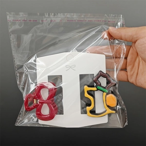 Detail of red bow hair clip and yellow dotted hair claw in transparent packaging card