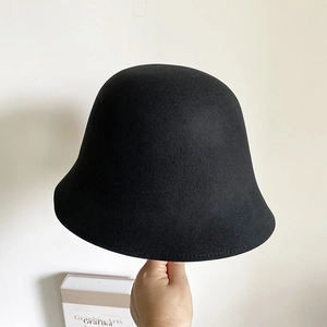 Détail d'un chapeau cloche en laine noire avec une texture en feutre et couronne ronde