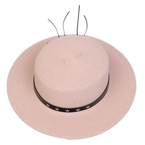 Top view of pink straw sun hat with black band and metal star decorations