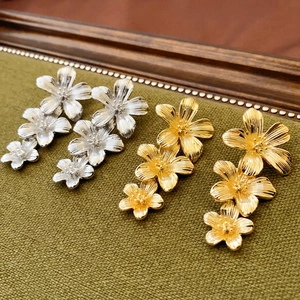 Vintage gold and silver tiered floral drop earrings with a metallic brushed texture