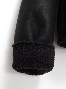 Close-up of black faux suede jacket cuff with thick faux shearling lining detail