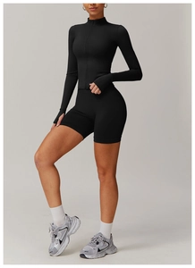 Detail view of black yoga set showing zipper top and thumb hole cuffs with biker shorts