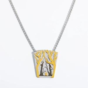 Macro view of vintage stainless steel forest necklace pendant with bird and trees