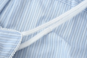 Detailed close-up of light blue striped top with white lace trim and thin straps