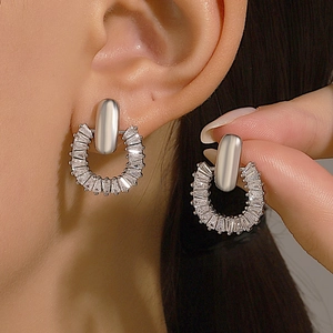 Sparkling silver hoop earrings with clear cubic zirconia on female model