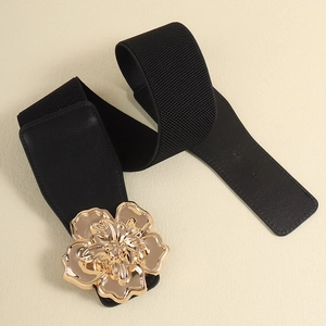 Détail d'une large ceinture élastique noire avec une grande boucle fleurie dorée