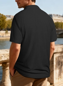 Outdoor shot of men's black polo shirt showing fabric texture and elegant casual fit