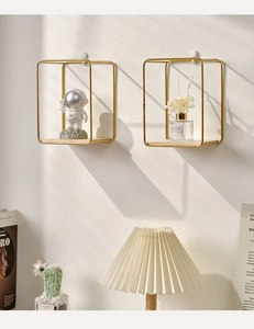 Close-up of golden wire floating shelves with wood base on a warm beige wall