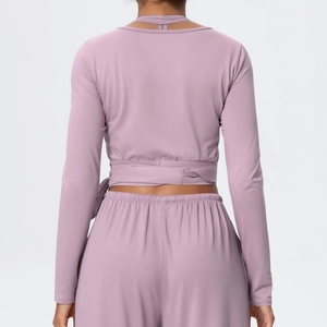 Rear view of long sleeve yoga top featuring cross-tie waist and high-waist lilac leggings