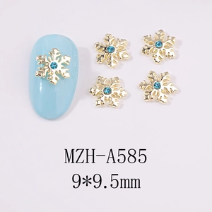 Détail d'un bijou d'ongle flocon de neige doré 9x9,5mm avec strass bleu pour manucure
