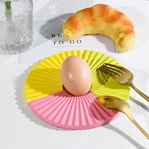 Detail of fan-shaped resin tray with pleated texture used as a stylish breakfast plate
