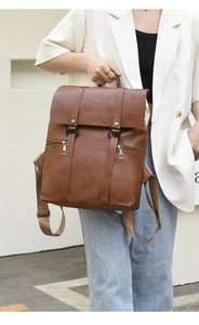 Detail eines braunen Lederrucksacks mit Klappdeckel und schwarzem Schnallenverschluss