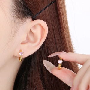 Close-up of elegant gold heart earrings with pink gemstones for a sweet style