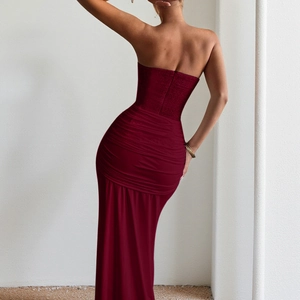 Detail view of burgundy strapless evening gown featuring a slim fit and back pleat design