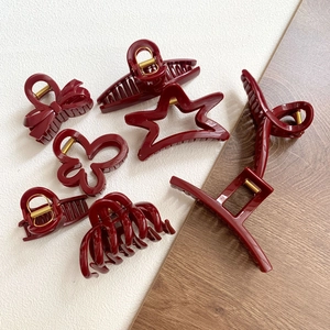 Detail view of various elegant red hair claws with high-gloss finish and gold springs