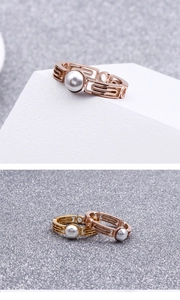 Detail of gold and rose gold geometric hollow rings with inlaid mother of pearl accents