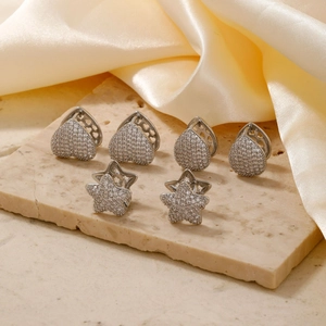 Minimalistische silberne Zirkon Stern und Herz Creolen Set auf elegantem Stein