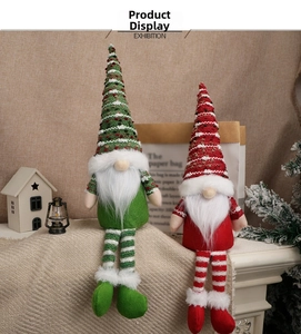 Detail of red and green knitted Christmas gnomes with long legs and white beards on a mantel