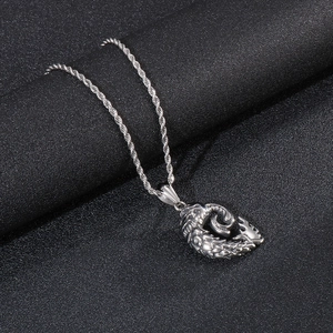 Detail of silver punk skull pendant with twisted rope chain on black texture background