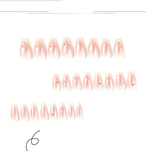 Macro view of coffin-shaped pink gradient nails with silver glitter and rhinestone details