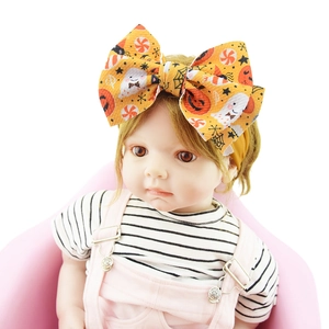 Halloween orange baby nylon headband with ghost and pumpkin print bow on a doll