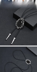 Close-up of vintage bolo tie with oval black stone and ornate silver metallic frame