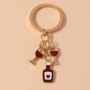 Detail of creative gold keychain with red wine bottle and wine glass pendants