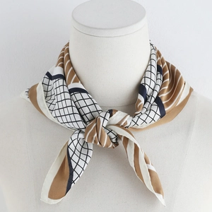 Detail of geometric pattern silk scarf tied on a white mannequin for neck decoration