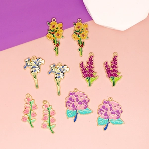 Flat lay of colorful enamel flower charms with gold frames for DIY jewelry making