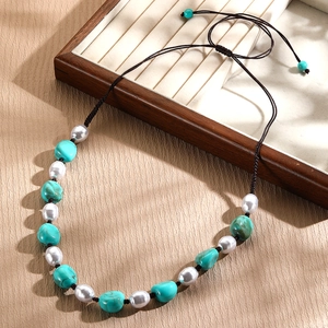 Detail of bohemian turquoise and pearl beaded necklace with adjustable brown cord