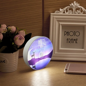 Macro detail of the round night light featuring a starry deer silhouette on a wood table