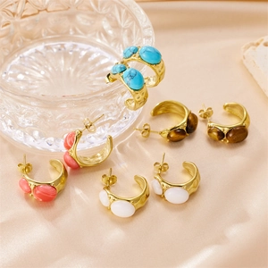 C-shaped stainless steel earrings with natural stones on a gold silk background