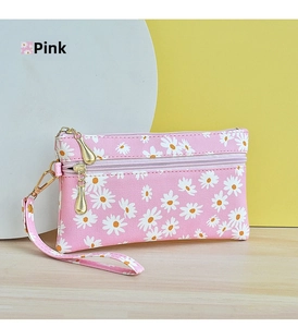 Close-up of pink floral clutch bag with double zipper and daisy pattern on wooden desk