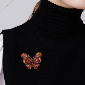 Detail of colorful butterfly brooch with vibrant rhinestones on a black sweater