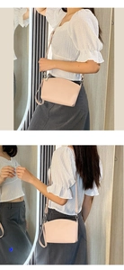 Detail showing pink crossbody bag with detachable strap paired with casual outfit