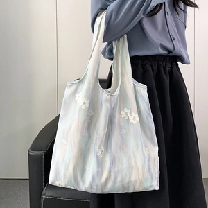 Détail du sac cabas en toile dégradé avec broderie florale blanche délicate et chic