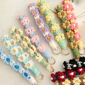 Detail of colorful hand-woven daisy flower keychains with golden metal ring clasps