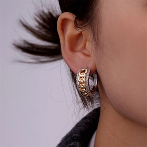 Detailed close-up of a twisted heart stud earring with sparkling zircons on ear