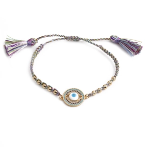 Macro detail of gold evil eye charm with colorful braided rope and inlaid crystals