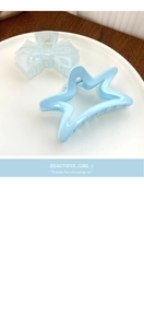 Detail of light blue bow and star shaped hair claws on a decorative white plate
